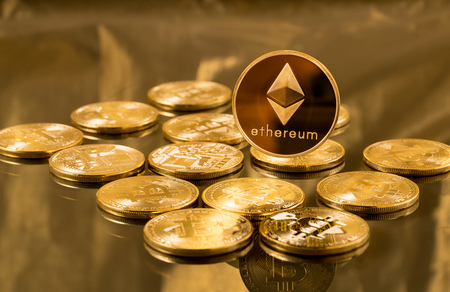 This is a photo of gold coins with the Bitcoin logo laying on a table. One gold coin with the Ethereum logo is standing above the fallen bitcoins. Ha ha. Suggestive, right?